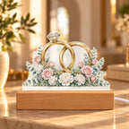Interlocked Rings — gold bands with a diamond, wrapped in roses and eucalyptus