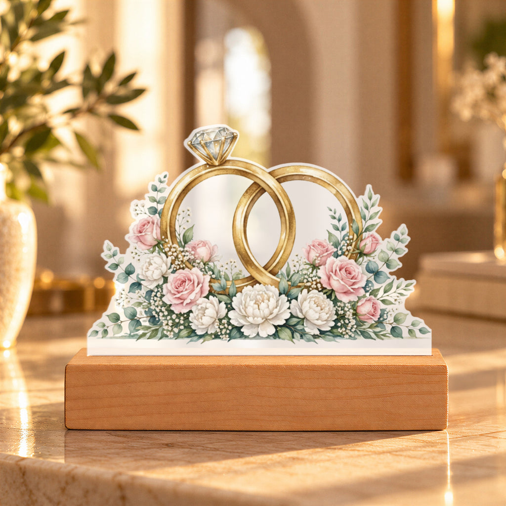 Interlocked Rings — gold bands with a diamond, wrapped in roses and eucalyptus
