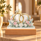 Interlocked Rings — gold bands with a diamond, wrapped in roses and eucalyptus